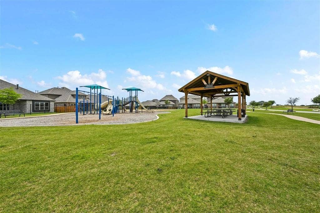 602 Brock Drive, Anna, TX 75409 Expansive green space featuring a playground structure, a covered picnic area, and paved walking paths
