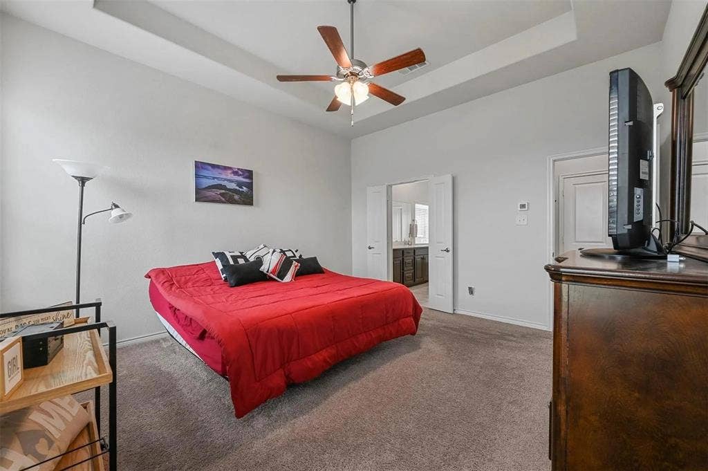 602 Brock Drive, Anna, TX 75409 Tray ceiling with a ceiling fan, neutral carpeting, and double doors opening to an adjoining room