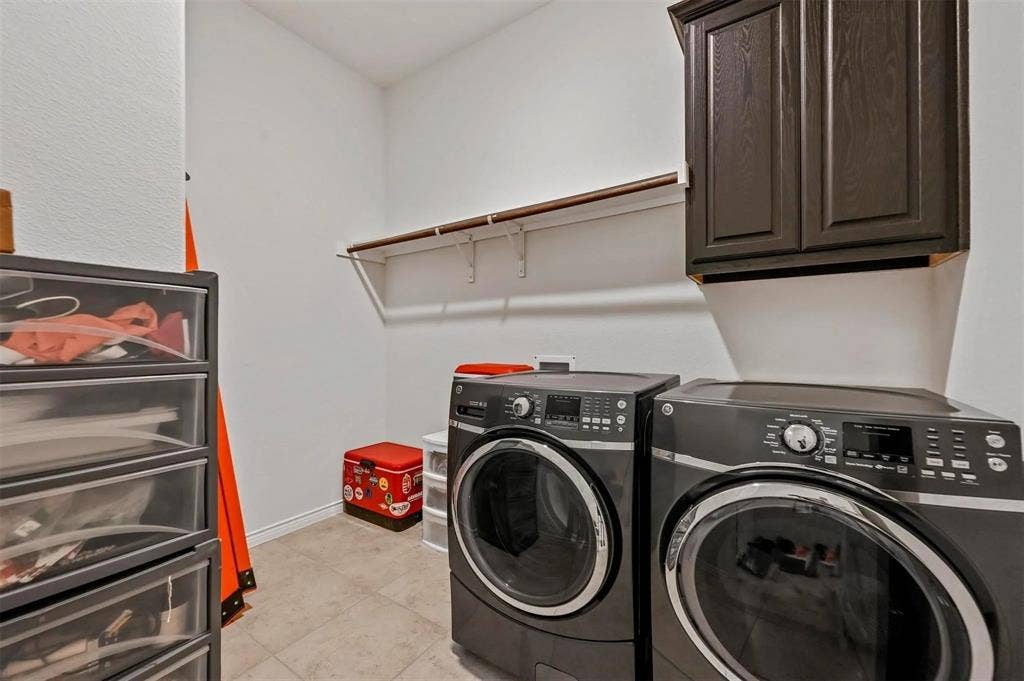 602 Brock Drive, Anna, TX 75409 Laundry area featuring tile flooring, a built-in wall cabinet, and a wall-mounted shelving unit with a hanging rod