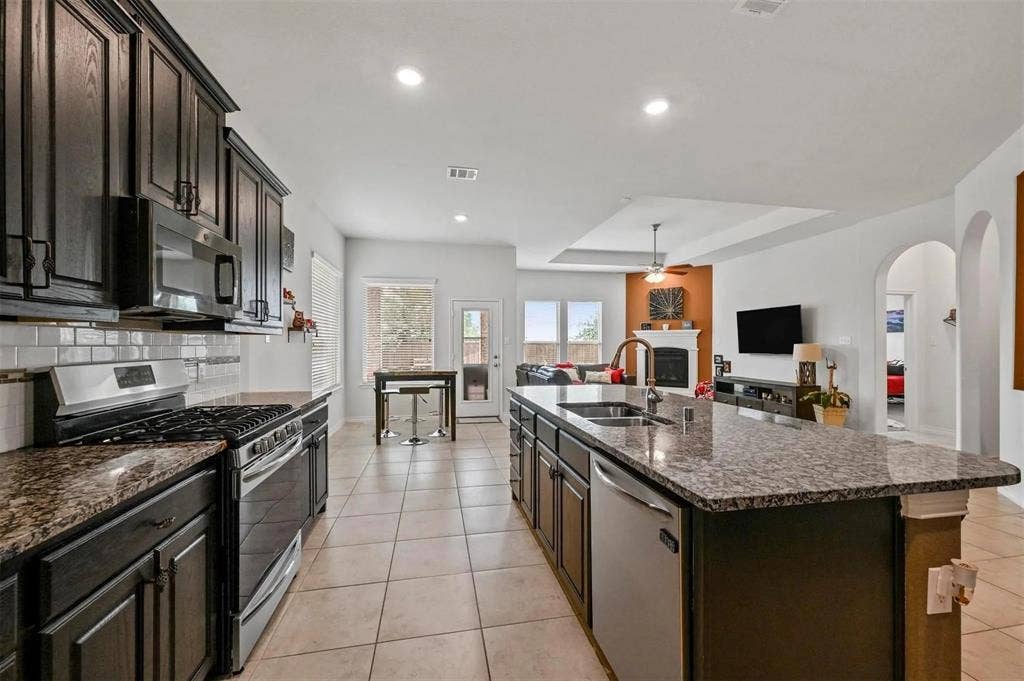 602 Brock Drive, Anna, TX 75409 Kitchen features dark wood cabinetry, granite countertops, and stainless steel appliances