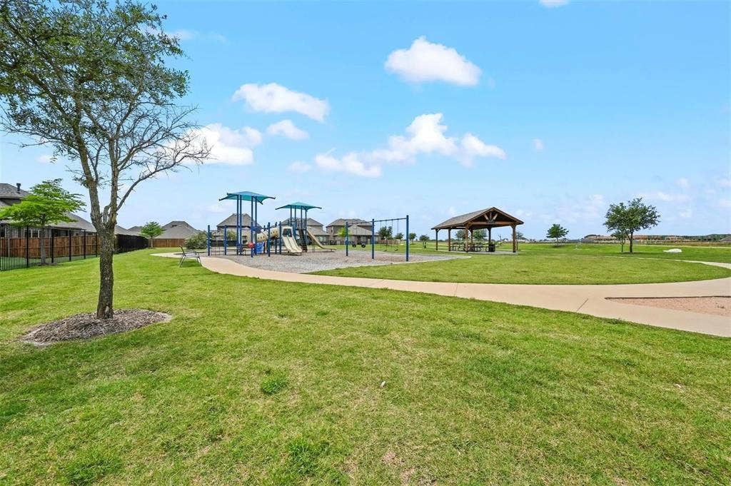 602 Brock Drive, Anna, TX 75409 Expansive green space featuring a playground with shade structures, a covered picnic area, and paved walking paths