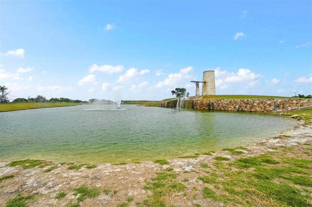 602 Brock Drive, Anna, TX 75409 Water feature with fountain, stone-clad retaining wall, and a decorative tower