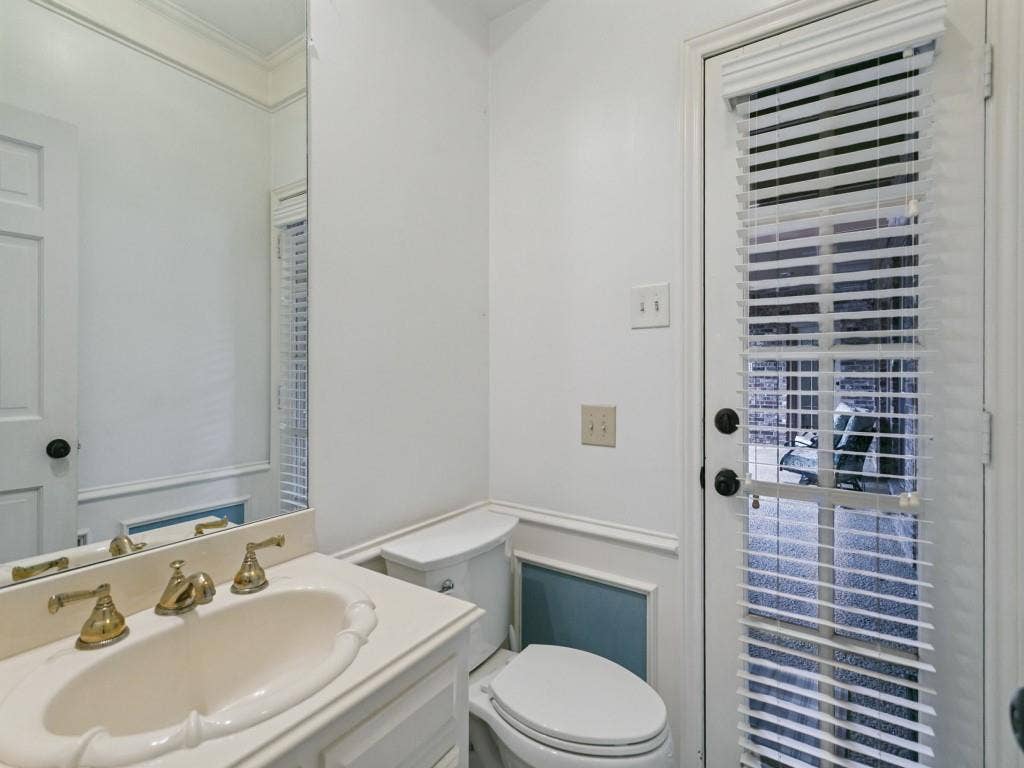 3309 Wolfe Court, Plano, TX 75025 Vanity with an integrated oval sink and brass-finish faucet, built-in mirror, and crown molding