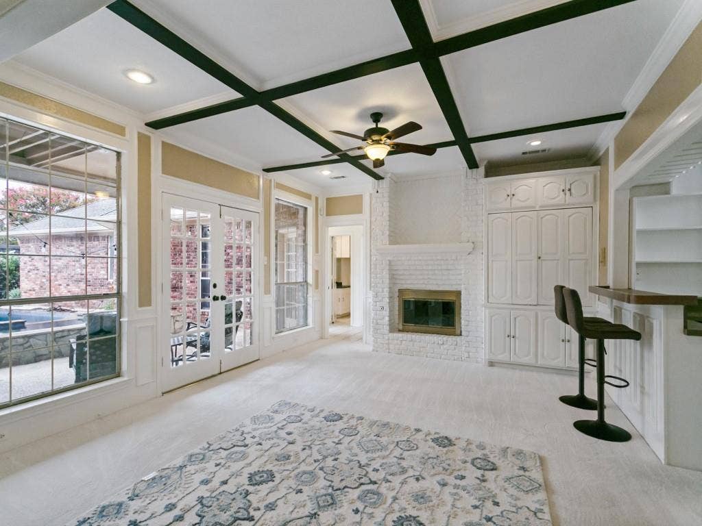 3309 Wolfe Court, Plano, TX 75025 Coffered ceiling with recessed lighting, whitewashed brick fireplace, built-in cabinetry, and French doors