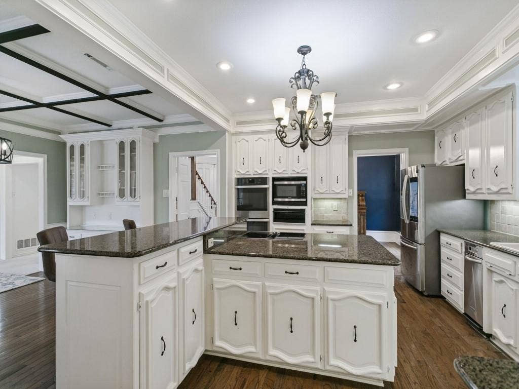 3309 Wolfe Court, Plano, TX 75025 Spacious kitchen with white cabinetry and dark granite countertops