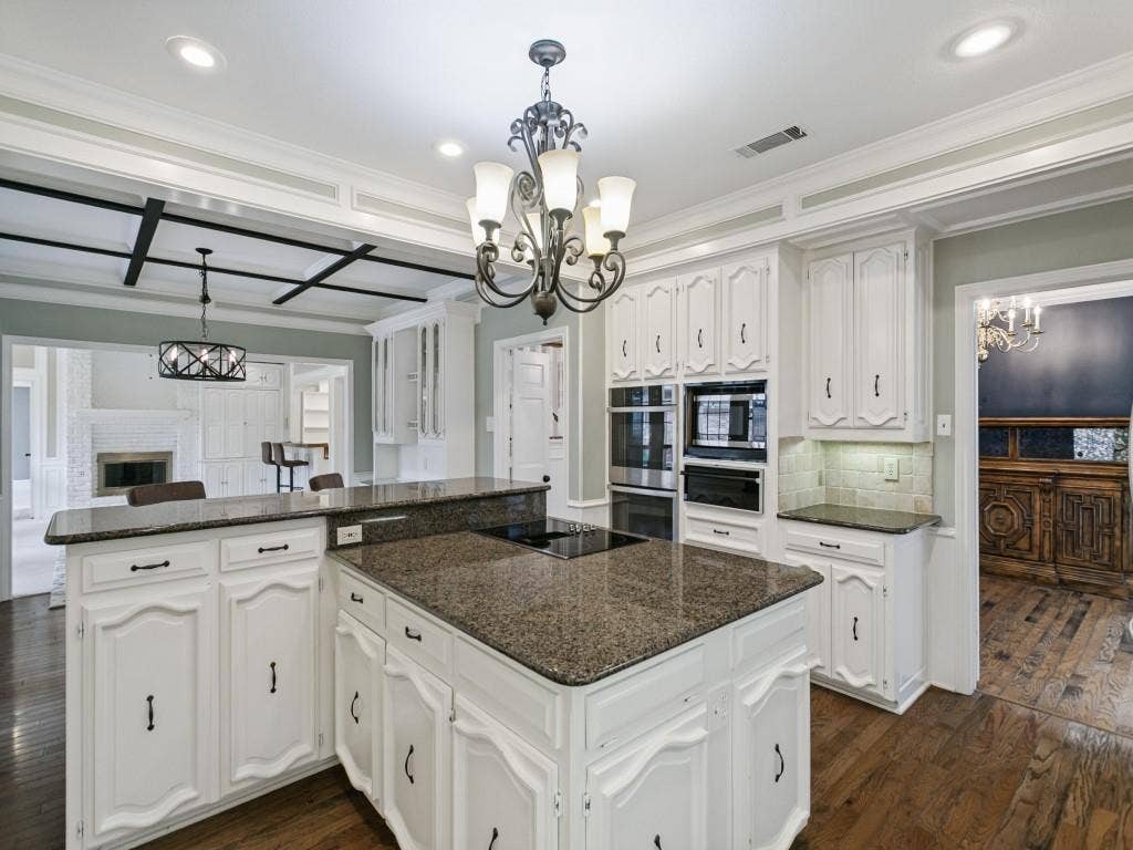 3309 Wolfe Court, Plano, TX 75025 Kitchen featuring white cabinetry, granite countertops, built-in double ovens, and wood-finish flooring