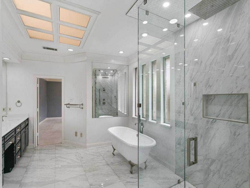 3309 Wolfe Court, Plano, TX 75025 Freestanding clawfoot tub, glass-enclosed shower with a rainfall showerhead, and a dual vanity with undermount sinks