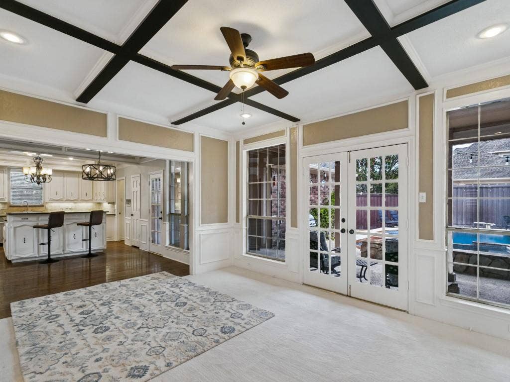 3309 Wolfe Court, Plano, TX 75025 Coffered ceiling with dark wood beams, white paneled walls, French doors, and large windows