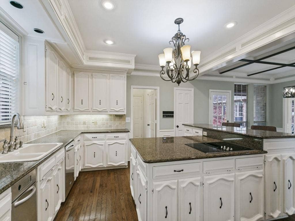 3309 Wolfe Court, Plano, TX 75025 Kitchen featuring white cabinetry, wood-finish flooring, granite countertops, and an island with a built-in cooktop