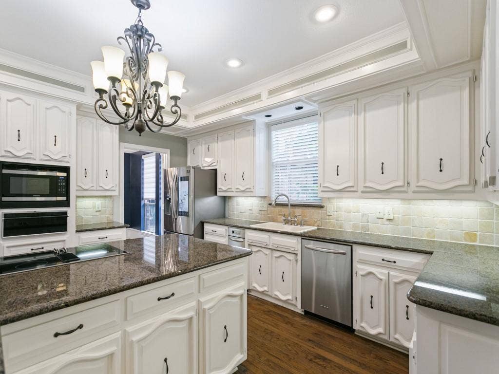 3309 Wolfe Court, Plano, TX 75025 Kitchen featuring white cabinetry, dark stone countertops, stainless steel appliances, and wood-finish flooring