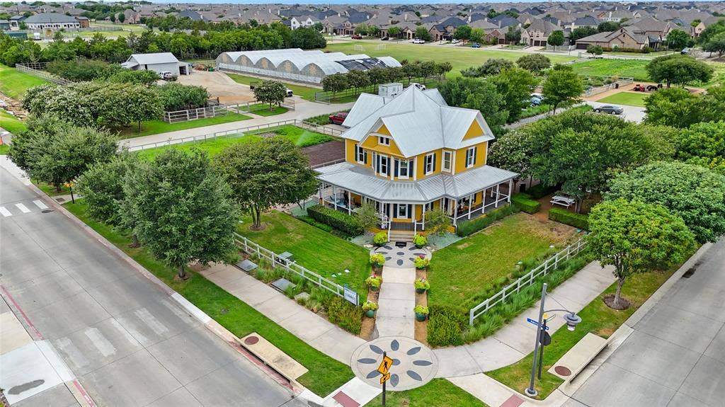 Victorian-style exterior with a wrap-around porch, prominent gable roof, and yellow siding