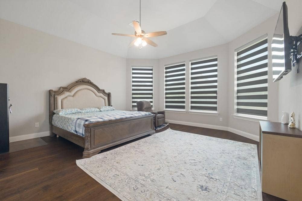 Vaulted ceiling with a ceiling fan, recessed bay windows, wood-finish flooring