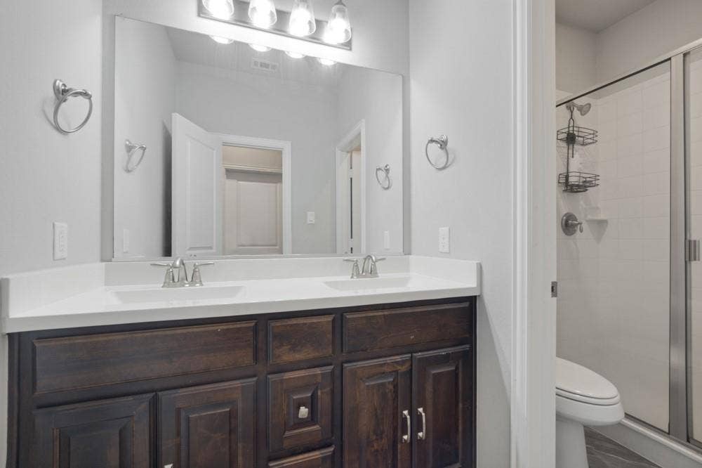 Double vanity with white countertop and dark wood-finish cabinetry