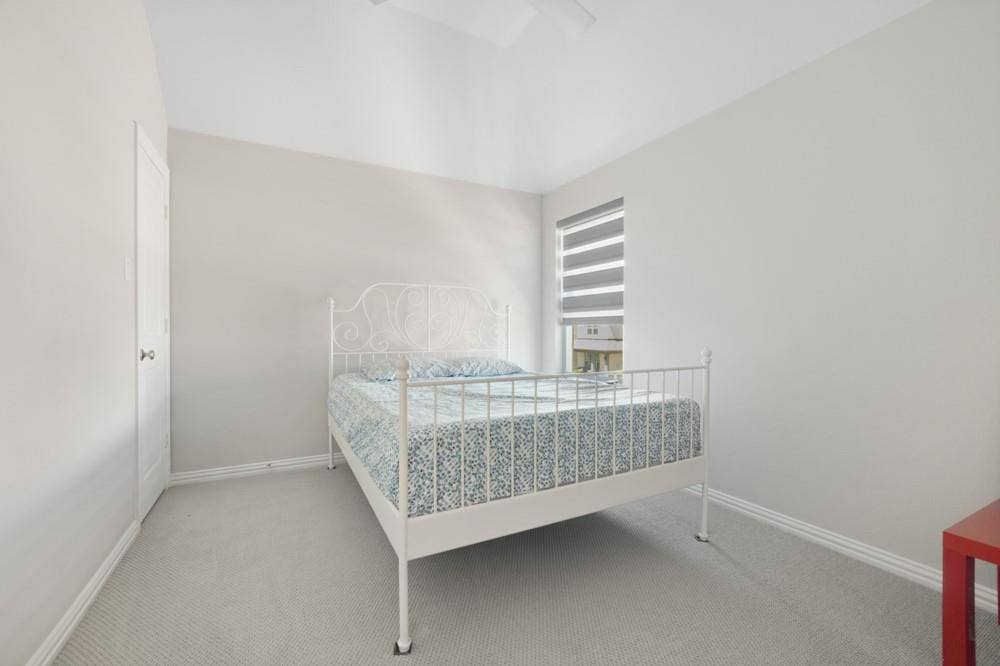 Recessed lighting, carpet flooring, and a single window with horizontal blinds