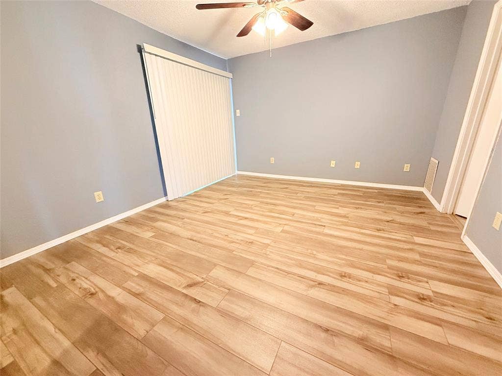 3402 Country Club Drive W, #154, Irving, TX 75038 Vaulted ceiling with an integrated ceiling fan, wood-finish flooring, and light-colored wall paint
