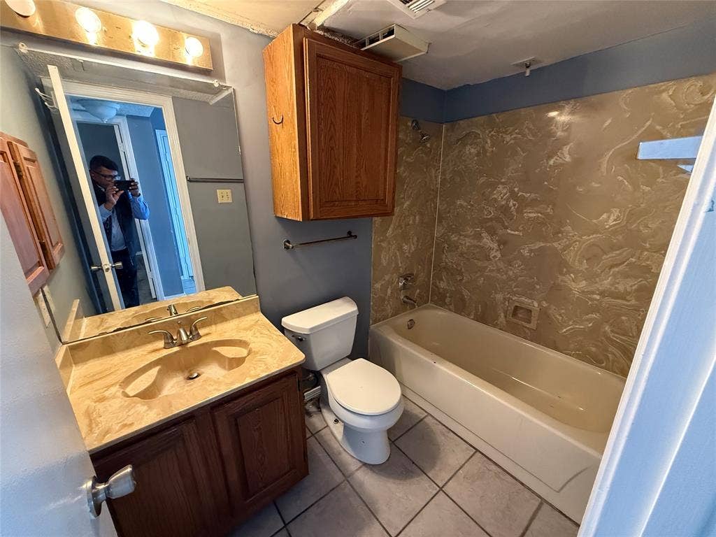 3402 Country Club Drive W, #154, Irving, TX 75038 Bathroom with a built-in bathtub, a vanity with an integrated sink, a wall-mounted medicine cabinet, and tiled flooring