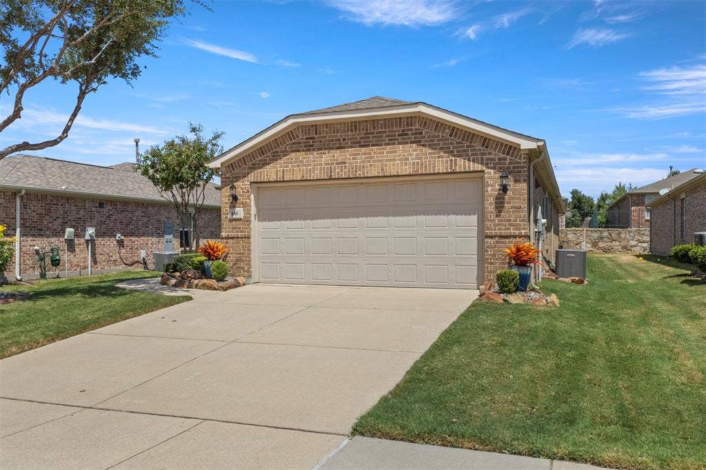 146 Montague Lane, Frisco, TX 75036 Brick exterior with an attached garage, concrete driveway, and established landscaping