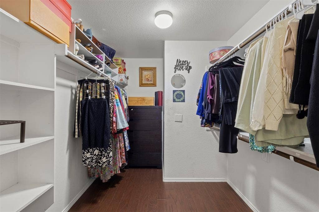 146 Montague Lane, Frisco, TX 75036 Walk-in closet featuring wood-finish flooring, built-in shelving, and multiple hanging rods