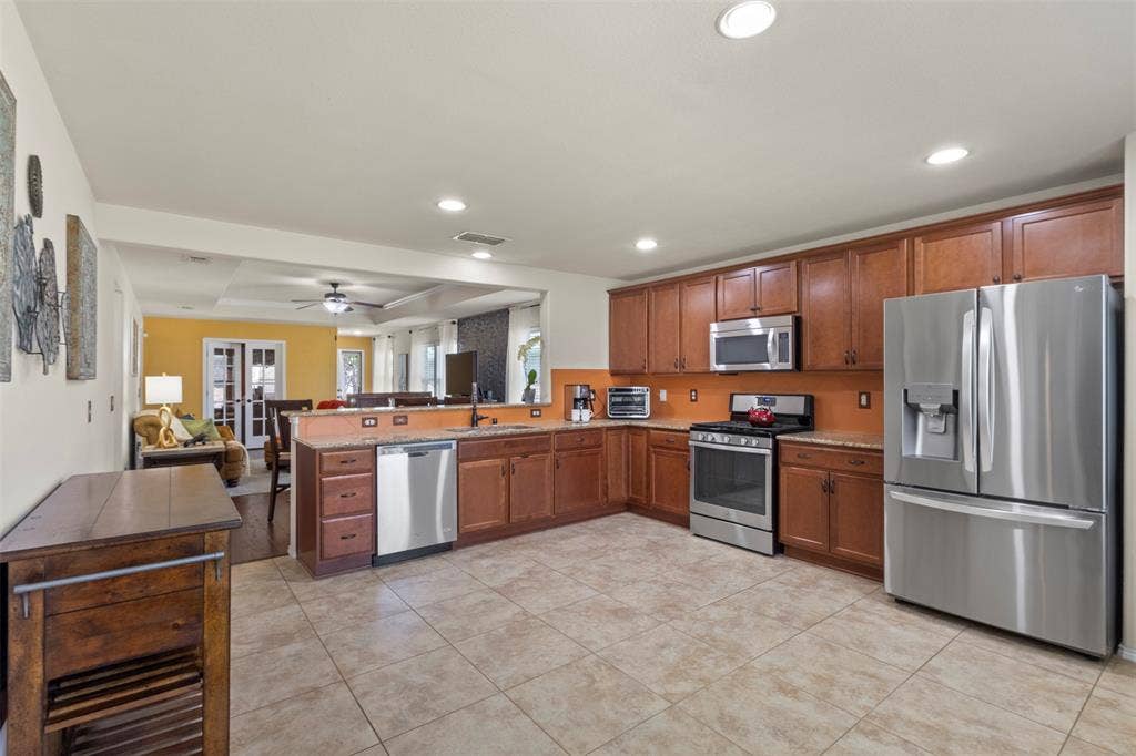 146 Montague Lane, Frisco, TX 75036 Kitchen featuring stainless steel appliances, wood cabinetry, recessed lighting, and tiled flooring