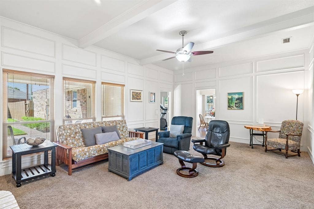 3441 Sheffield Circle, Plano, TX 75075 Expansive living space featuring wall paneling, a ceiling fan, carpet flooring, and multiple windows