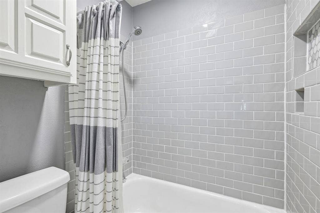 3441 Sheffield Circle, Plano, TX 75075 Recessed shower niche with hexagonal tile accent, subway tile surround, white porcelain tub, and chrome showerhead
