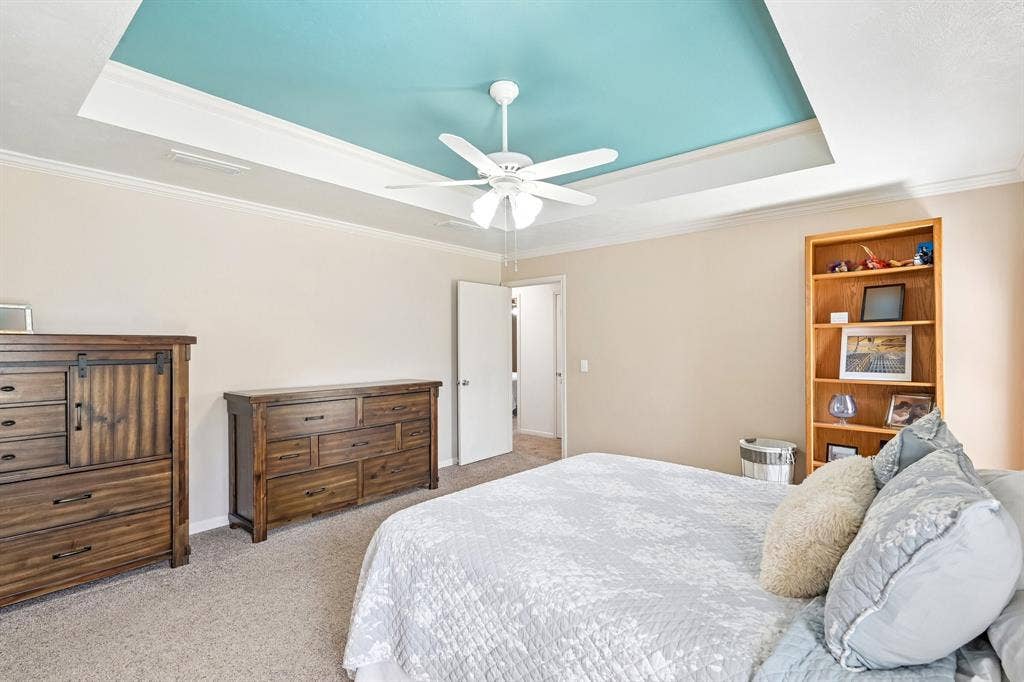 3441 Sheffield Circle, Plano, TX 75075 Tray ceiling with accent color, crown molding, ceiling fan, and carpeted flooring