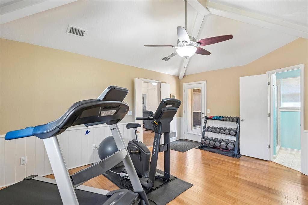 3441 Sheffield Circle, Plano, TX 75075 Vaulted ceiling with exposed beams, wood-finish flooring, beadboard wainscoting, and a ceiling fan with integrated lighting