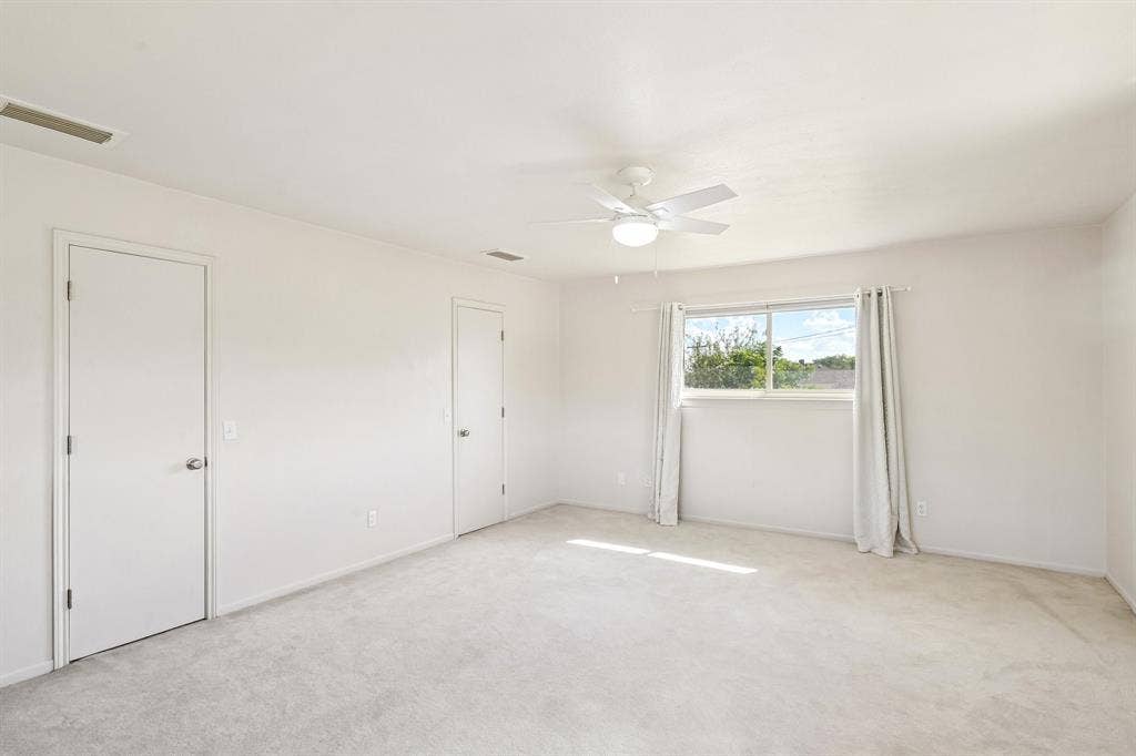 3441 Sheffield Circle, Plano, TX 75075 Expansive room with neutral carpeting, white walls, a ceiling fan with integrated lighting, and multiple doors
