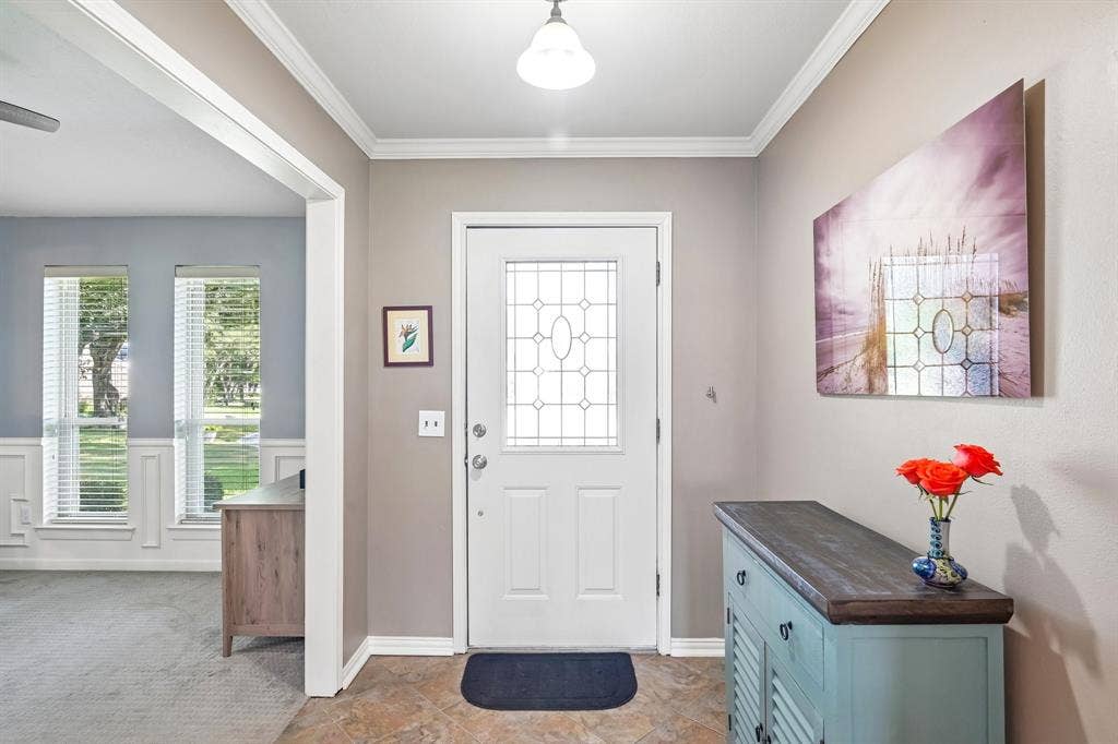3441 Sheffield Circle, Plano, TX 75075 Entryway featuring decorative glass paneled front door, crown molding, and tiled flooring