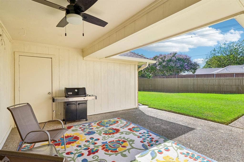 3441 Sheffield Circle, Plano, TX 75075 Covered patio with a ceiling fan, textured concrete flooring, and a spacious green lawn