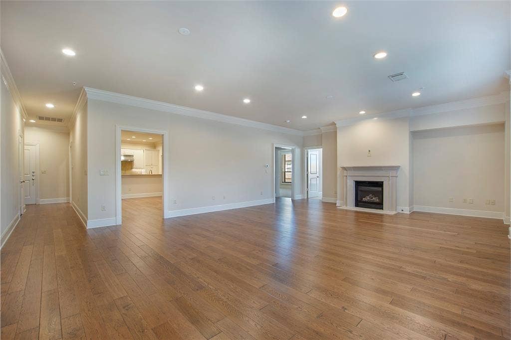 6425 Bandera Avenue, #2E, Dallas, TX 75225 Unfurnished living room featuring ornamental molding and light wood-type flooring