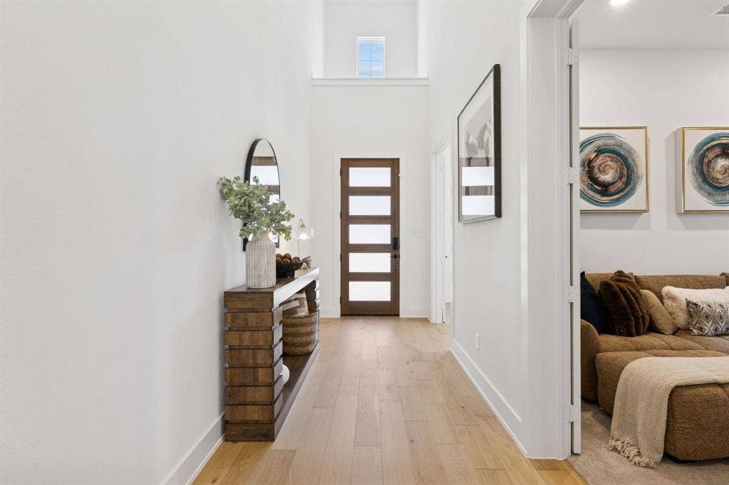 1117 Bradford Street, Celina, TX 75009 Bright entryway featuring wood-finish flooring, a contemporary front door with frosted glass panels, and a high ceiling with an upper window