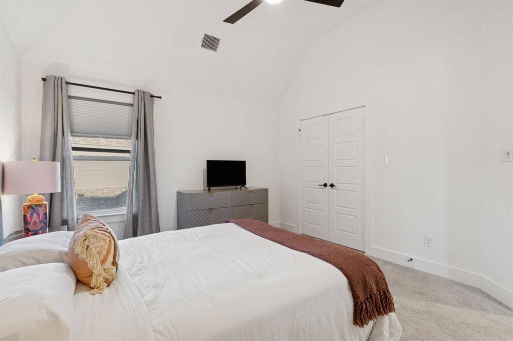 1117 Bradford Street, Celina, TX 75009 Vaulted ceilings enhance this carpeted room featuring a window with blinds and drapes, a ceiling fan, and double panel doors