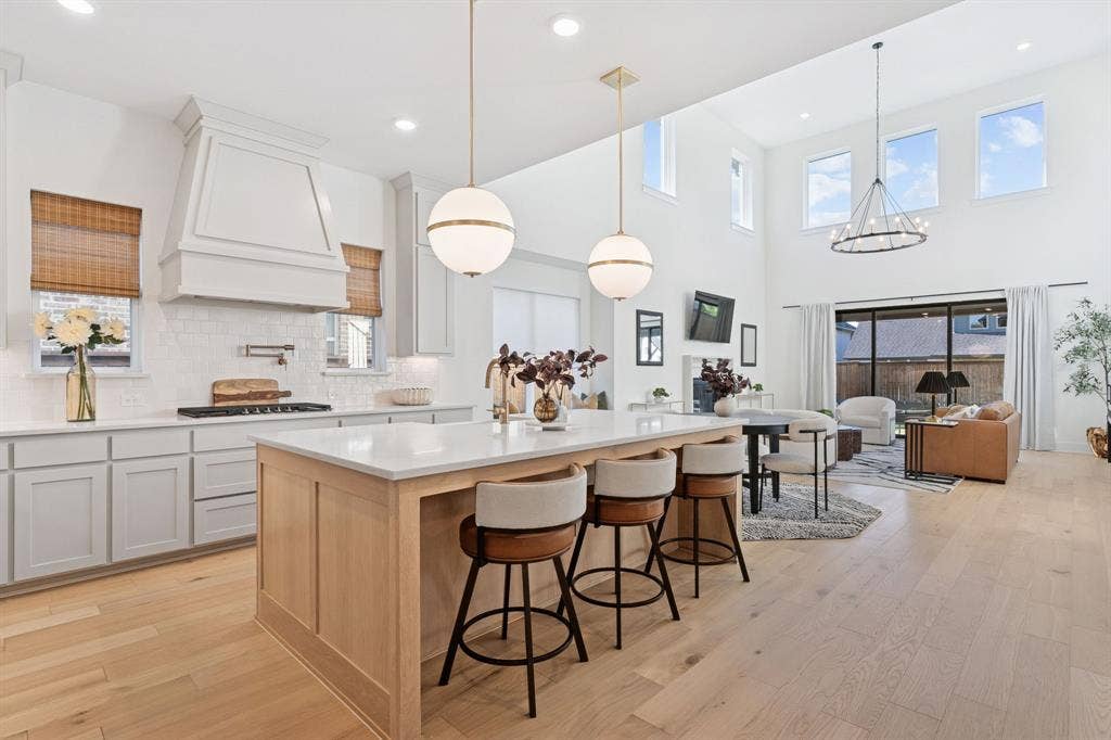 1117 Bradford Street, Celina, TX 75009 Gourmet kitchen featuring a light wood island with seating, white countertops, subway tile backsplash, and a custom range hood