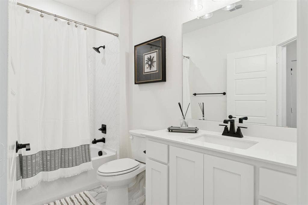 1117 Bradford Street, Celina, TX 75009 Bathroom featuring a white vanity with an undermount sink, a white countertop, and matte black fixtures