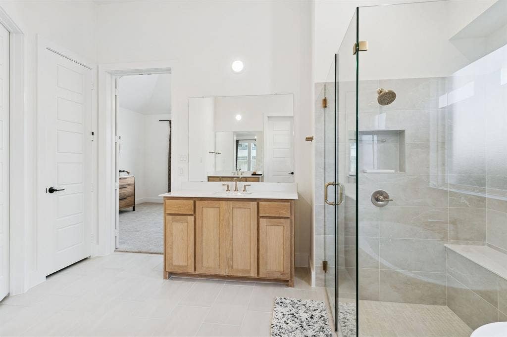 1117 Bradford Street, Celina, TX 75009 Spacious bathroom featuring a glass-enclosed shower with a built-in bench and recessed niche