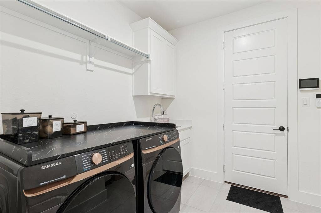 1117 Bradford Street, Celina, TX 75009 Dedicated utility space featuring bright white walls, white tile flooring, white shaker-style cabinetry, and a stainless steel sink with a chrome faucet