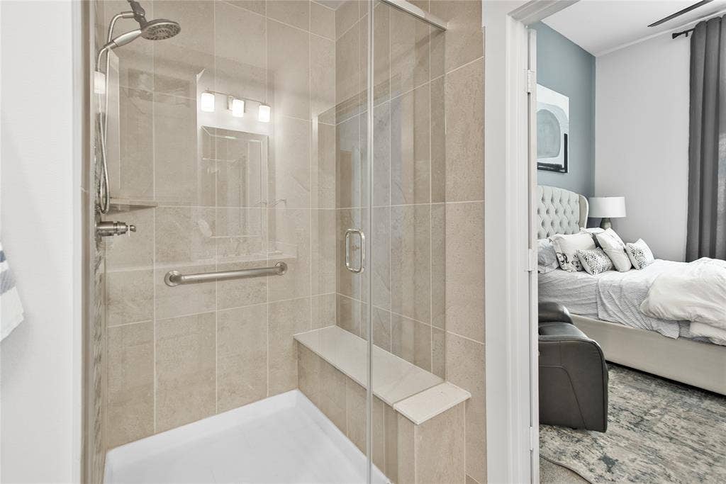 2644 Chardonnay Court, Grand Prairie, TX 75054 Glass-enclosed shower with full tile surround, built-in bench, handheld shower fixture, and grab bar