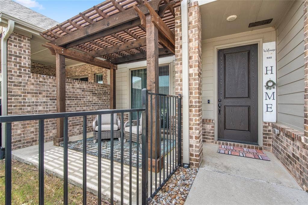 2644 Chardonnay Court, Grand Prairie, TX 75054 Covered patio with a wood pergola, brick accent walls, and a dark-paneled entry door
