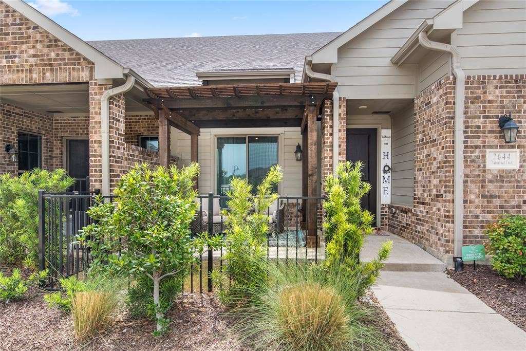 2644 Chardonnay Court, Grand Prairie, TX 75054 Brick exterior with siding accents, covered entry, front patio with a wood pergola, and mature landscaping