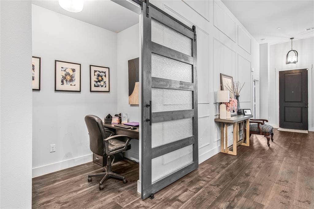 2644 Chardonnay Court, Grand Prairie, TX 75054 Wood-finish flooring throughout, a sliding barn door with frosted glass panels, and a paneled accent wall