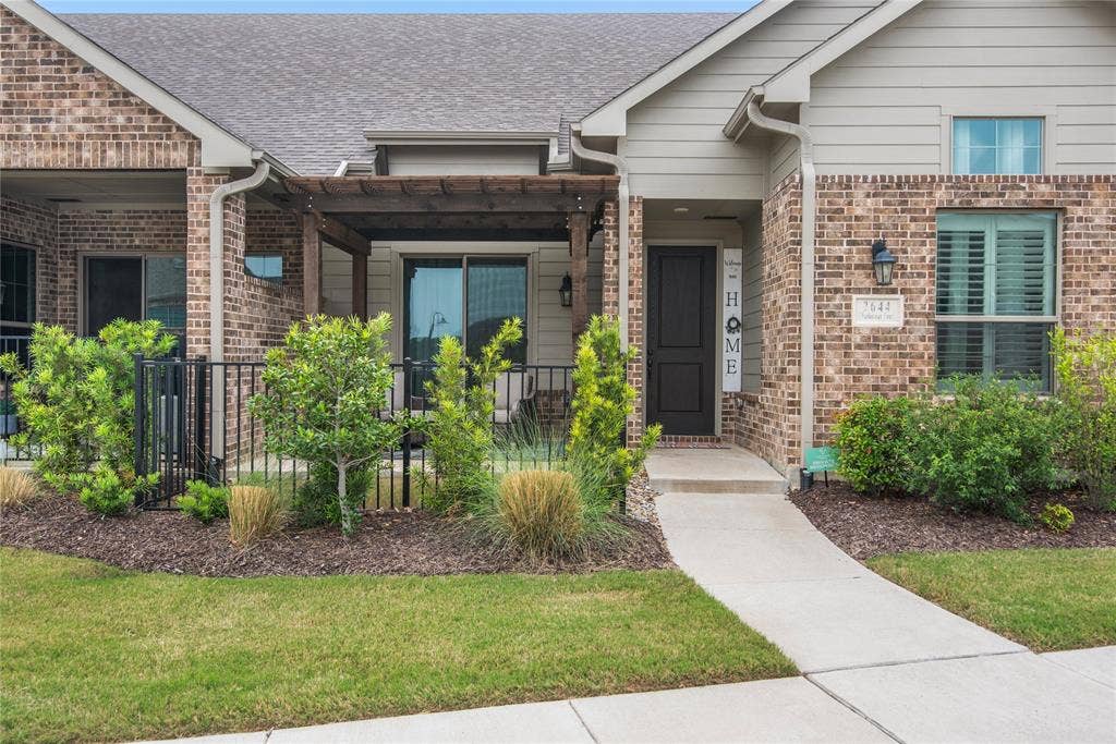 2644 Chardonnay Court, Grand Prairie, TX 75054 Brick and siding exterior, front entry with dark paneled door, covered patio with wood pergola, mature landscaping, and concrete walkway