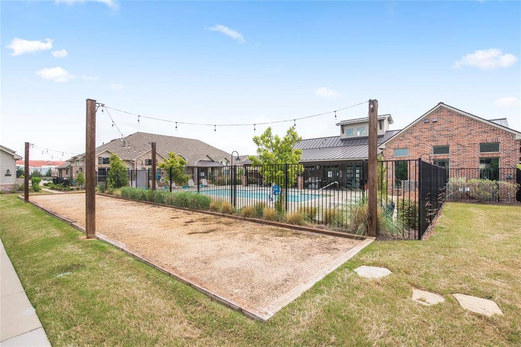 2644 Chardonnay Court, Grand Prairie, TX 75054 Bocce ball court with string lighting, adjacent to a fenced swimming pool and brick structure