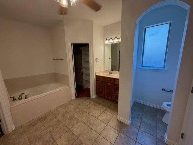 500 Leatherman Drive, Saginaw, TX 76179 Bathroom featuring a built-in soaking tub, wood-finish vanity with countertop, wall-mounted lighting, and a separate toilet alcove