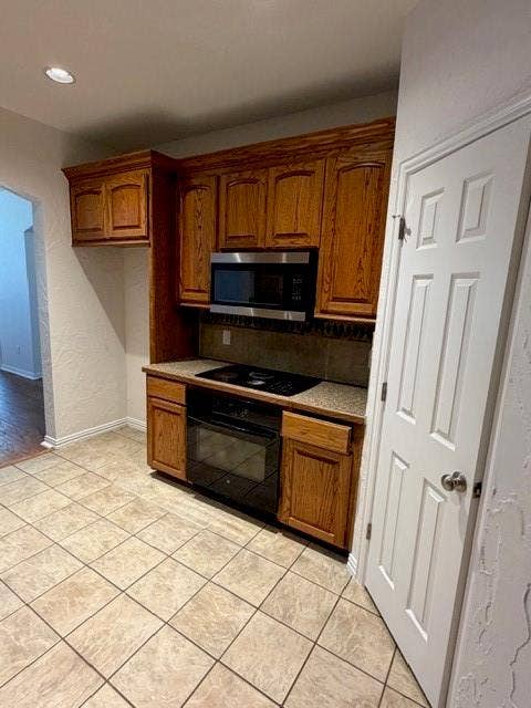 500 Leatherman Drive, Saginaw, TX 76179 Built-in microwave, electric cooktop, and oven within wood cabinetry