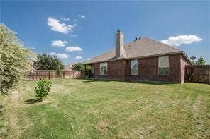 500 Leatherman Drive, Saginaw, TX 76179 Expansive fenced backyard featuring a brick exterior, covered patio, and mature landscaping