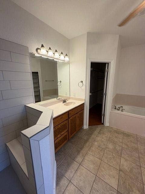 500 Leatherman Drive, Saginaw, TX 76179 Dual vanity with wood-finish cabinetry, a large mirror, and overhead lighting
