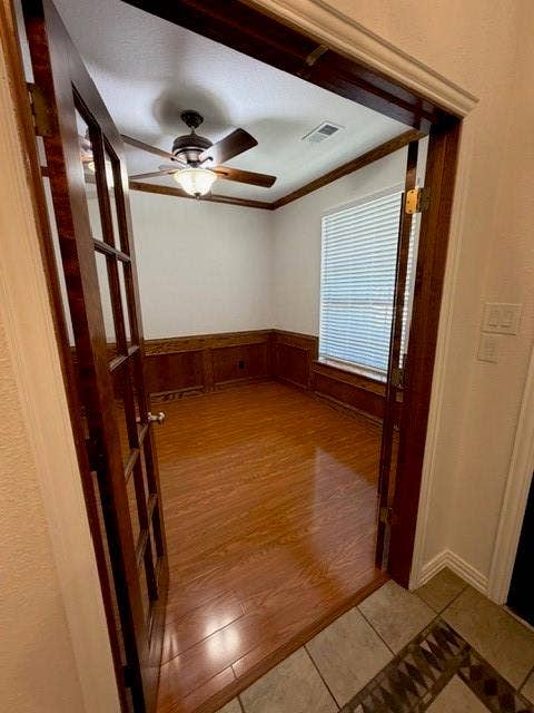 500 Leatherman Drive, Saginaw, TX 76179 Wood-finish flooring, wood-paneled wainscoting, a ceiling fan with integrated lighting, window blinds, and French doors