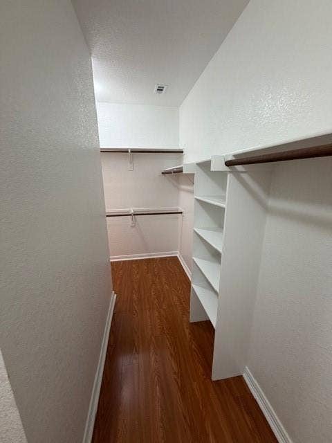 500 Leatherman Drive, Saginaw, TX 76179 Walk-in closet with wood-finish flooring, white walls, built-in shelving, and multiple hanging rods