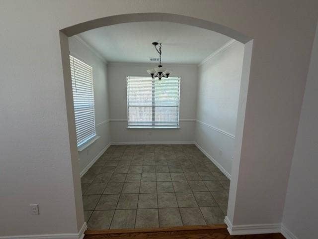 500 Leatherman Drive, Saginaw, TX 76179 Arched entry to a room featuring tile flooring, dual windows with blinds, a chandelier, and crown molding